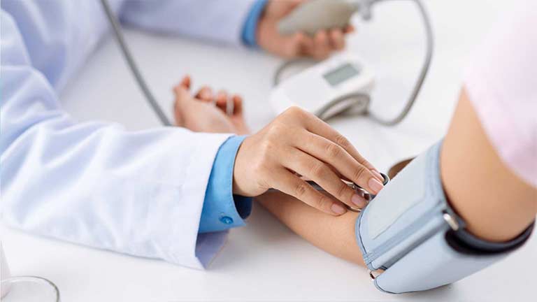 Doctor checking patient blood pressure