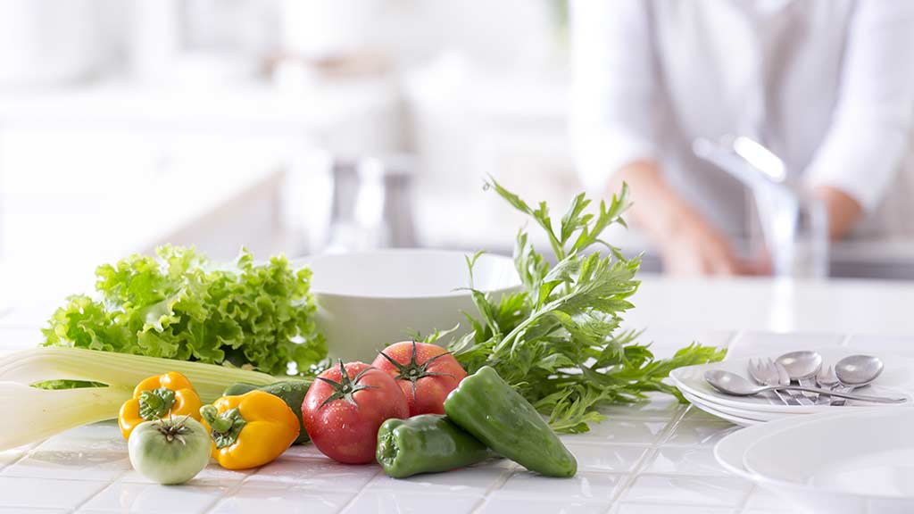 Kitchen counter with red, green, and yellow vegetables